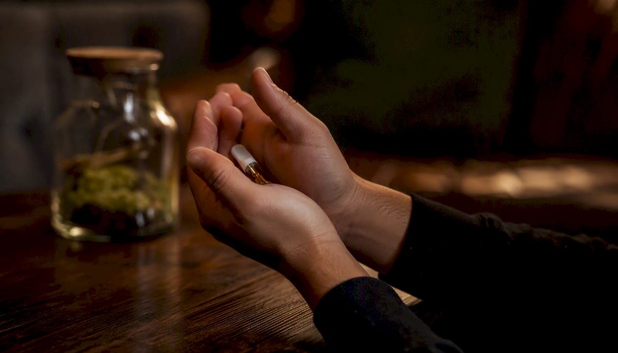 Hands gently warming vape cartridge