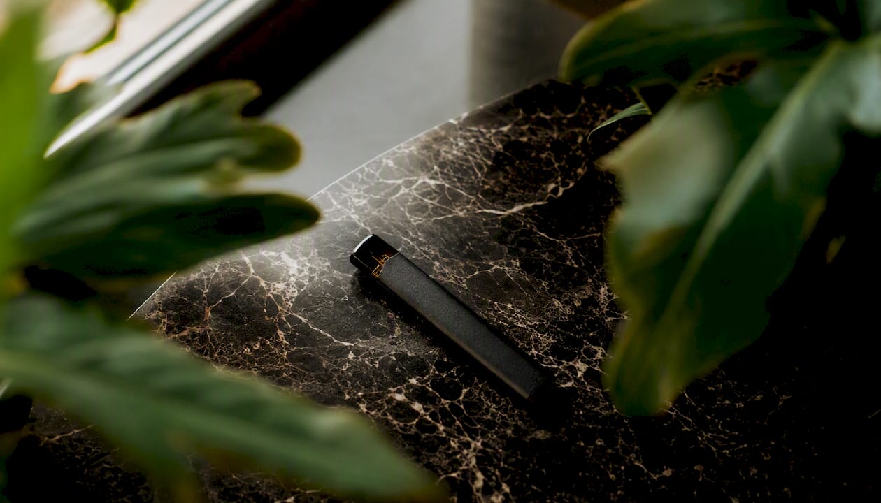 Close-up of disposable vape pen on leather surface