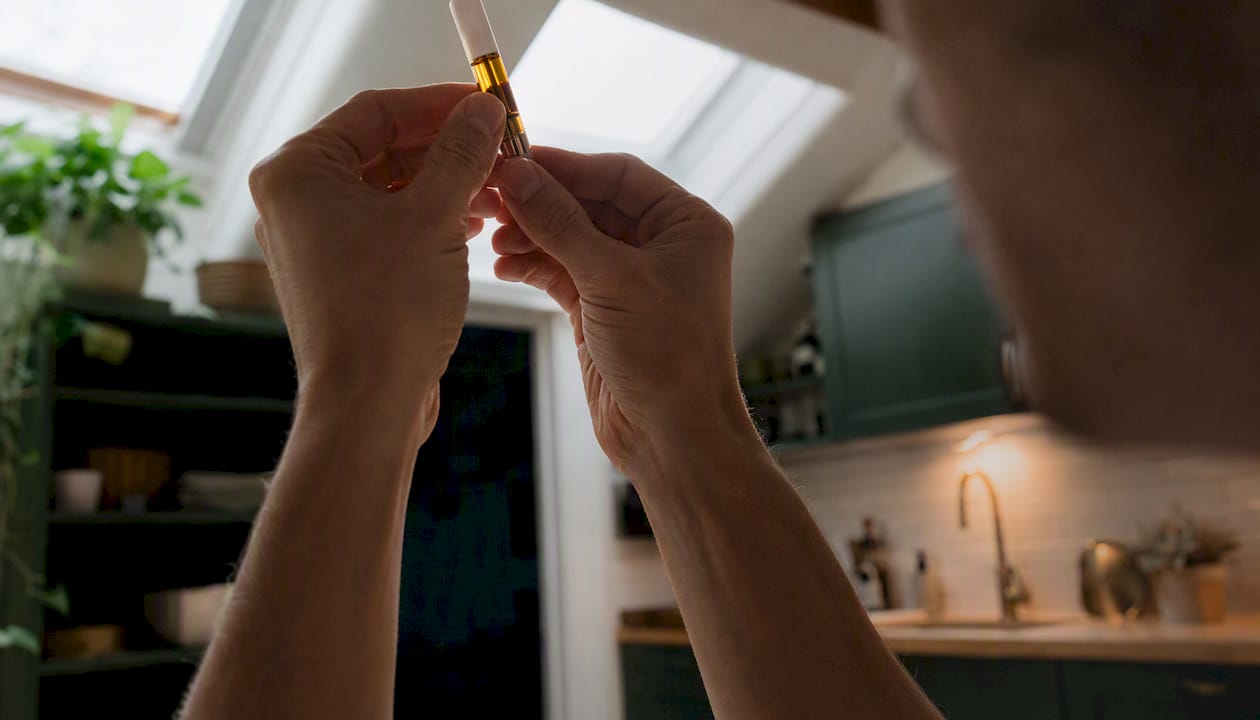 Hands inspecting vape cartridge oil color